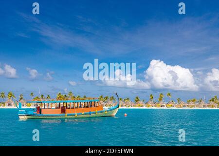 Perfetto isola tropicale paradiso spiaggia Maldive. Lungo molo e una barca tradizionale Dhoni. Estate viaggio turismo paesaggio, mare blu laguna spiaggia villa Foto Stock