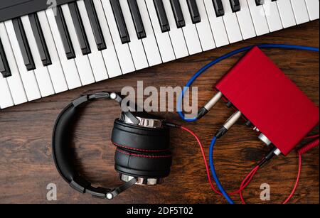 Piano, cuffie e scheda audio. Studio di musica per la casa. Foto Stock