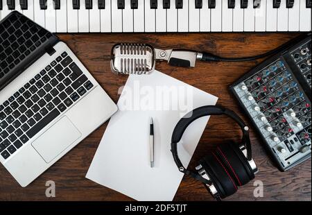 Attrezzatura da studio musicale e carta bianca con penna. Concetto di scrittura di canzoni. Foto Stock