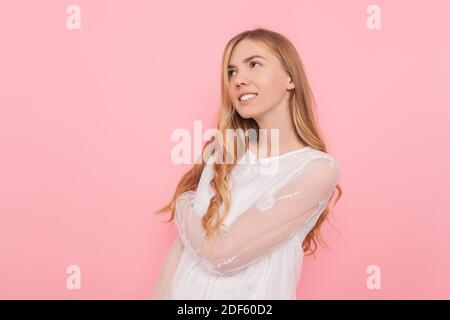 Bella ragazza pensierosa in un vestito bianco, sogni di qualcosa, facendo piani Foto Stock