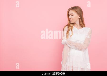 Bella ragazza pensierosa in un vestito bianco, sogni di qualcosa, facendo piani Foto Stock