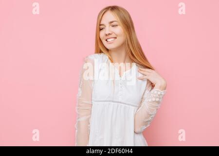 Felice ragazza pensierosa in un vestito bianco, sogni di qualcosa, facendo piani Foto Stock