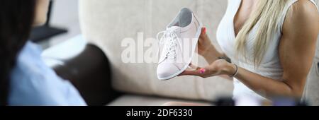 Donna dimostra scarpe e fa video revisione. Foto Stock