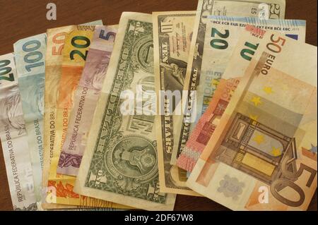 Banconote in reais brasiliano, euro e dollari su un tavolo. Foto Stock