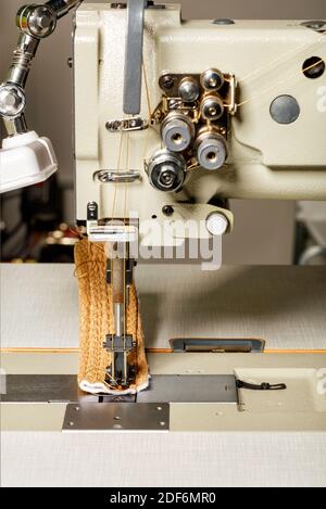 Parte di lavoro della macchina da cucire industriale per la produzione di tappezzeria di mobili, closeup. Foto Stock