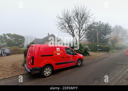 Un piccolo furgone rosso di consegna della posta reale parcheggiato su un Strada di campagna a Shepperton Surrey Inghilterra Regno Unito Foto Stock