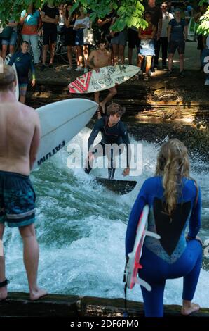 Surf sul fiume all'Eisbach a Monaco, Baviera, Germania. L'Eisbach è un piccolo fiume di due chilometri, costruito dall'uomo, situato nel centro di Monaco il 27 luglio 2019 Foto Stock