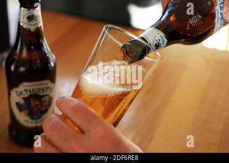 Dr assetata birra bionda dalla Wychwood Brewery in Oxfordshire versato in un bicchiere Foto Stock