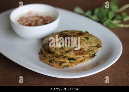 Un sano pane piatto indiano chiamato Methi poori fatto di farina integrale mescolata con foglie di Fenugreek, buon sapore se servito con cagliata mescolata con indiana Foto Stock