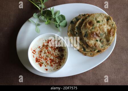 Un sano pane piatto indiano chiamato Methi poori fatto di farina integrale mescolata con foglie di Fenugreek, buon sapore se servito con cagliata mescolata con indiana Foto Stock