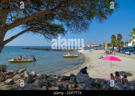 Francia, Herault, laguna di Thau, Meze, turisti su una spiaggia con pedalò Foto Stock