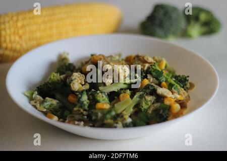 Uova strapazzate con broccoli, mais dolce e cipollotti, una colazione sana Foto Stock