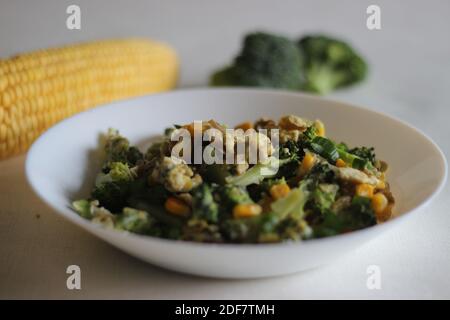 Uova strapazzate con broccoli, mais dolce e cipollotti, una colazione sana Foto Stock