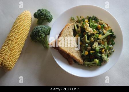 Uova strapazzate con broccoli, mais dolce e cipollotti, una colazione sana Foto Stock