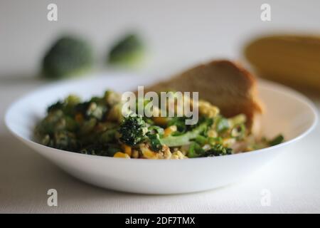 Uova strapazzate con broccoli, mais dolce e cipollotti, una colazione sana Foto Stock