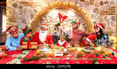 Foto di gruppo di una famiglia di più generazioni sui vestiti dei cappelli di santa Divertirsi al party natalizio - Vacanza invernale concetto di x mas Foto Stock