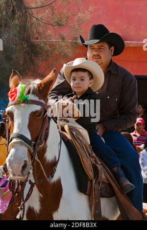 CABALLEROS o cowboy messicani, sia giovani che vecchi, entrano in città per celebrare la festa DELLA VERGINE DI GUADALUPE - LOS RODRIGUEZ, GUANAJUATO, MEXI Foto Stock