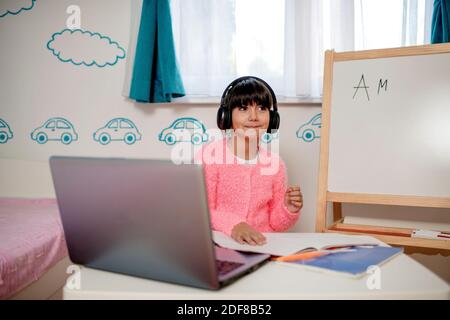 La ragazza della scuola sta studiando in linea. Scuola domestica. Formazione a distanza. Foto Stock