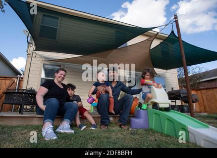 I genitori Nicole e Brandon Overton e la loro famiglia, Greeley (pantaloni arancioni), 1, Saben (shorts blu), 4, e Kafry (shorts rossi), 6, a casa loro nel sud di Austin. Foto Stock