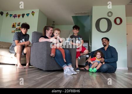 I genitori Nicole e Brandon Overton e la loro famiglia, Greeley (pantaloni arancioni), 1, Saben (shorts blu), 4, Kafry (shorts rossi), 6 e Mayken, 16, a casa loro nel sud di Austin. Foto Stock