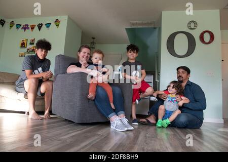 I genitori Nicole e Brandon Overton e la loro famiglia, Greeley (pantaloni arancioni), 1, Saben (shorts blu), 4, Kafry (shorts rossi), 6 e Mayken, 16, a casa loro nel sud di Austin. Foto Stock