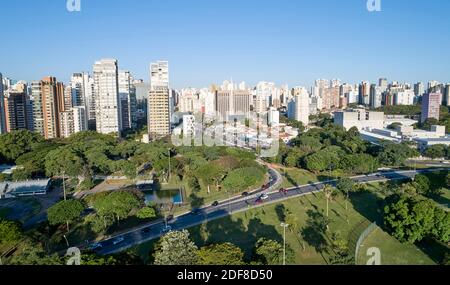 Vista aerea della città di Sao Paulo, traffico in viale 23 de Maio, corridoio nord-sud. Area di preversione con alberi e area verde del parco Ibirapuera Foto Stock