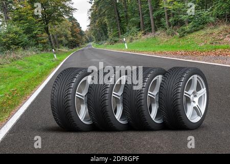 Set di ruote per auto - quattro ruote per auto disposte in una fila sulla strada asfaltata accanto alla foresta - Illustrazione 3D Foto Stock