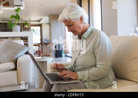 Donna caucasica anziana che usa un computer portatile Foto Stock