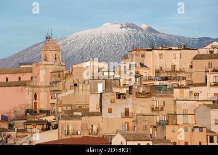 Vista delle case e del campanile della città di Centuripe in Sicilia, sullo sfondo il vulcano Etna in parte nevoso Foto Stock