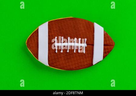Primo piano di pallone da calcio americano isolato su sfondo verde. Vista dall'alto. Foto Stock