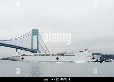 Handout photo datedMarch 30, 2020 of the Military Sealift Command Hospital ship USNS Comfort (T-AH 20) is scorted by U.S. Coast Guard, New York Police Department and New York Fire Department assets as the ship arrives in a New York City, March 30, 2020. Il comfort è stato implementato a sostegno degli sforzi di risposta COVID-19 della nazione e servirà come ospedale di riferimento per i pazienti non COVID-19 attualmente ricoverati in ospedali a terra. Ciò consente agli ospedali a terra di concentrare i propri sforzi sui casi COVID-19. Una delle missioni del Dipartimento della Difesa è il sostegno alla Difesa delle autorità civili. Phot Foto Stock