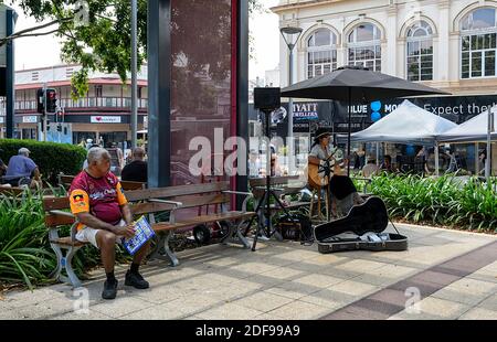 Busker femminile che suona la chitarra nel centro città, Maryborough, Sunshine Coast, Queensland, QLD, Australia Foto Stock