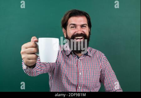 il docente universitario beve il caffè dopo la lezione. torna a scuola. formazione formale. giorno della conoscenza. insegnante con il bearded maturo alla lezione. lavoro brutale dell'uomo in classe con lavagna. preparati per l'esame. Foto Stock