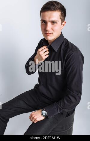 Il ragazzo nello Studio. Il ragazzo nel vestito nero. Bel ragazzo. Foto di alta qualità Foto Stock