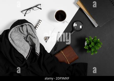 Maglione, notebook, tazza da caffè e oggetti personali su sfondo bianco e nero. Foto Stock