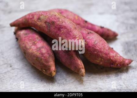 Patate dolci viola su tavolo di legno, yam viola Foto Stock