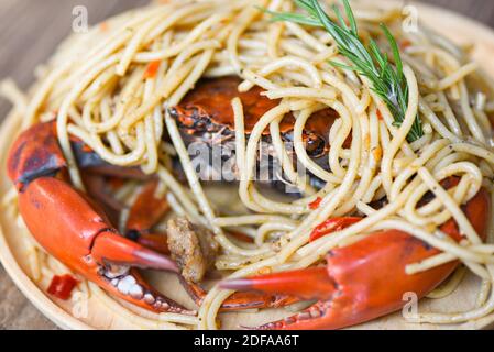 Granchio cotto su piatto con spezie e frutti di mare spaghetti sullo sfondo del cibo da tavola, granchio bollito Foto Stock