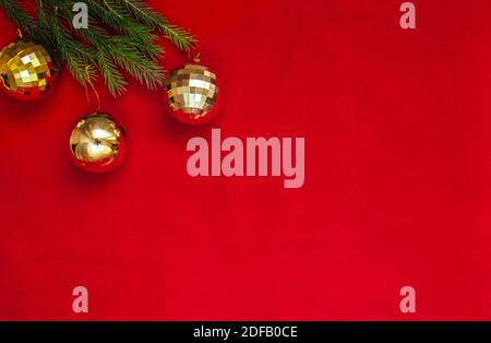 Sfondo di Natale. Palline dorate su sfondo rosso con posto per il testo. Foto Stock