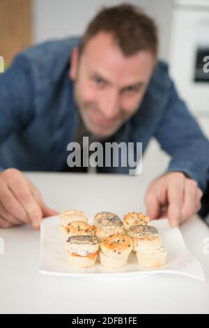 l'uomo sta preparando tapas per i visitatori a casa Foto Stock