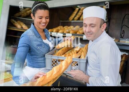 uomo e donna in panetteria uniforme che lavora in una panetteria Foto Stock