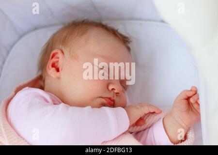 Bambina neonato con costume rosa che dorme in una culla all'aperto Foto Stock