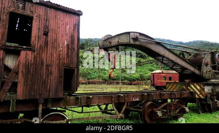 Vagone arrugginito e abbandonato fuori dalla ferrovia. Il carro marcio si trova in una foresta tropicale Foto Stock