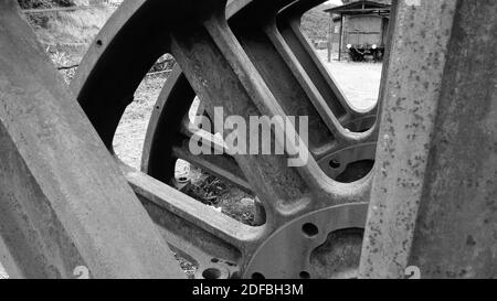 Vecchie ruote arrugginite in metallo del treno abbandonate nel campo [Nero E colori bianchi] Foto Stock