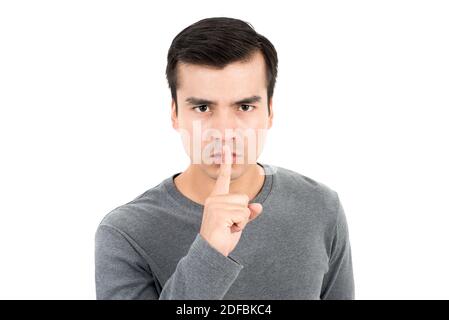 Giovane uomo che fa il gesto di hush (shh) - tranquillo o segreto segno Foto Stock