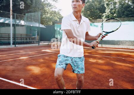 Fit Man gioca a tennis su campo Foto Stock