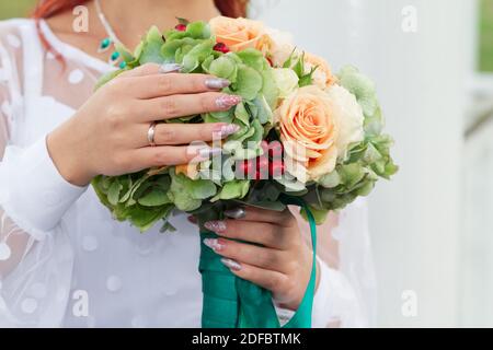 La sposa tiene un bel bouquet di rose nel suo giorno di nozze. Caratteristiche e decorazioni, organizzazione di matrimoni. Foto Stock