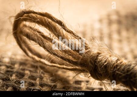 Corda di lino macro isolata su fondo di tessuto di lino Foto Stock