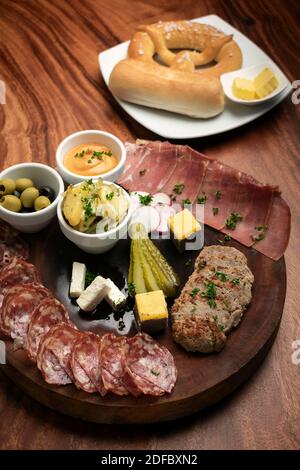 piatto di tapas a base di salumi tedeschi con carne e pane su sfondo tavola di legno Foto Stock