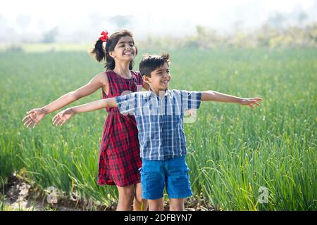 Felici i bambini che si divertono in campo agricolo Foto Stock