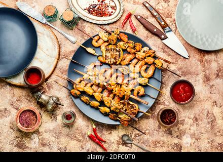 Deliziosi gamberi arrostiti e cozze su spiedini di legno Foto Stock